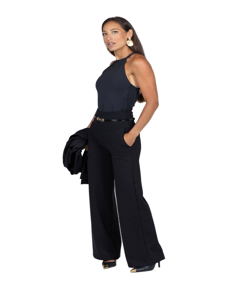 Woman wearing a black sleeveless top and wide-leg pants on a white background