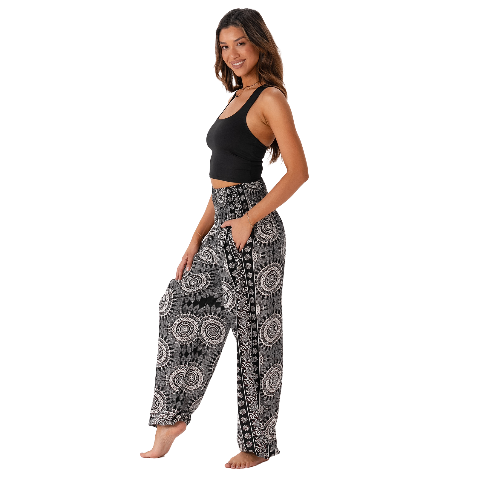 Woman wearing black and white patterned harem pants on a white background