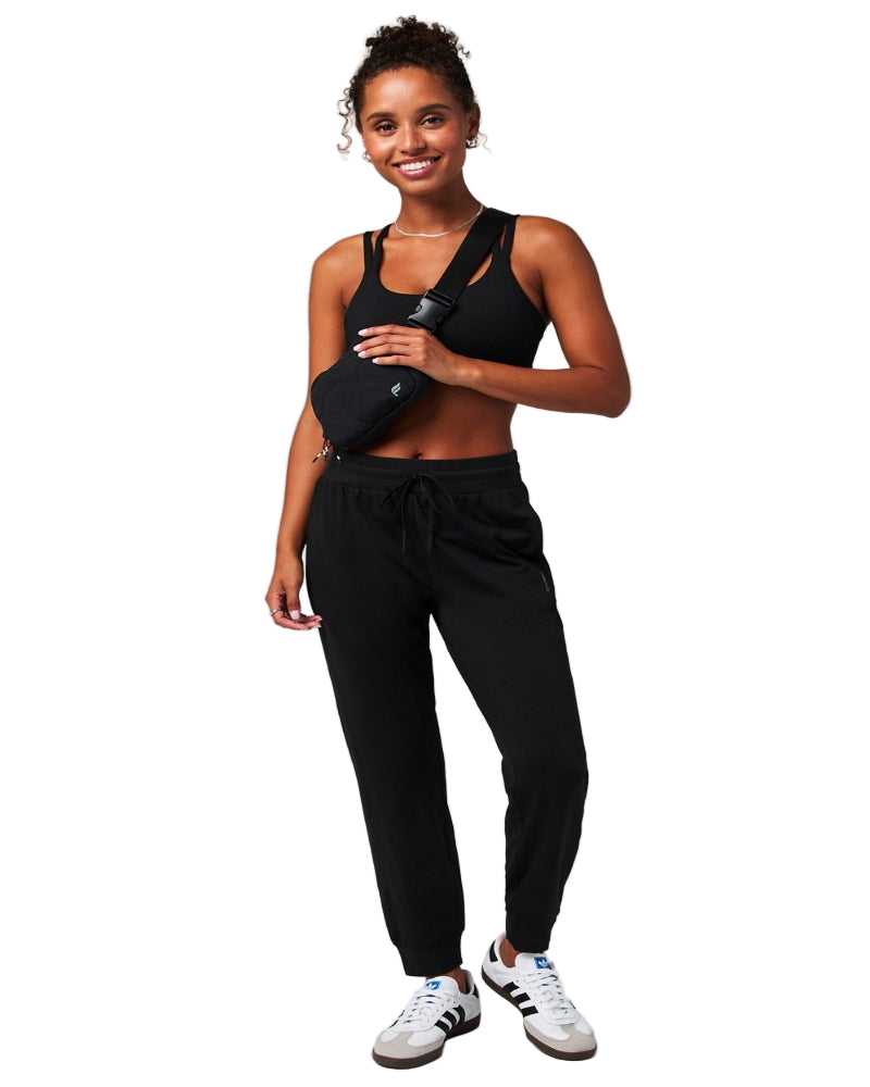 Woman wearing a black athletic outfit with a white background