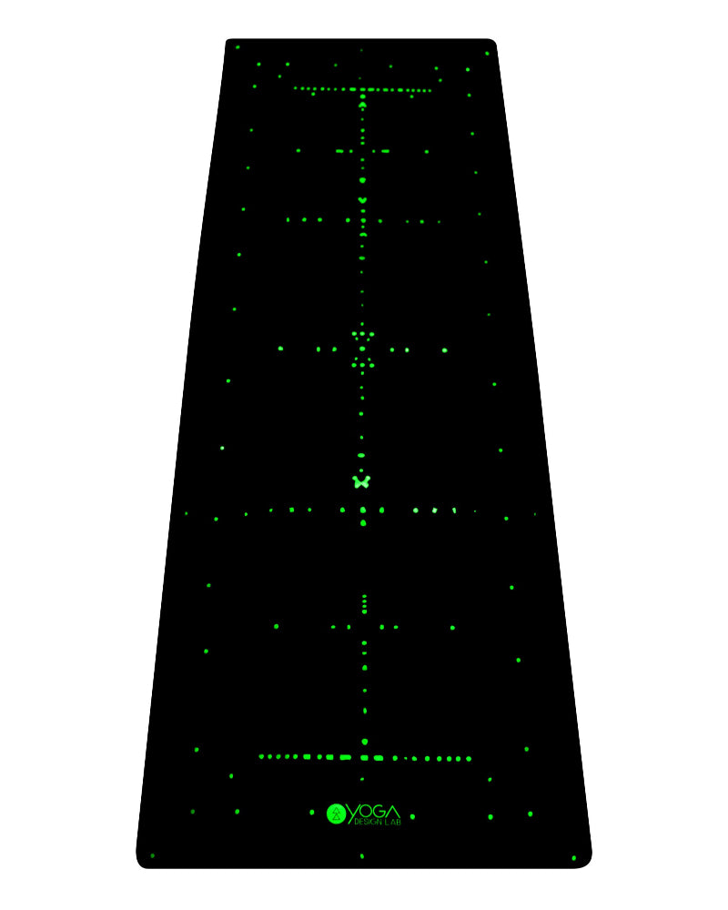 Black yoga mat with green patterns on a white background