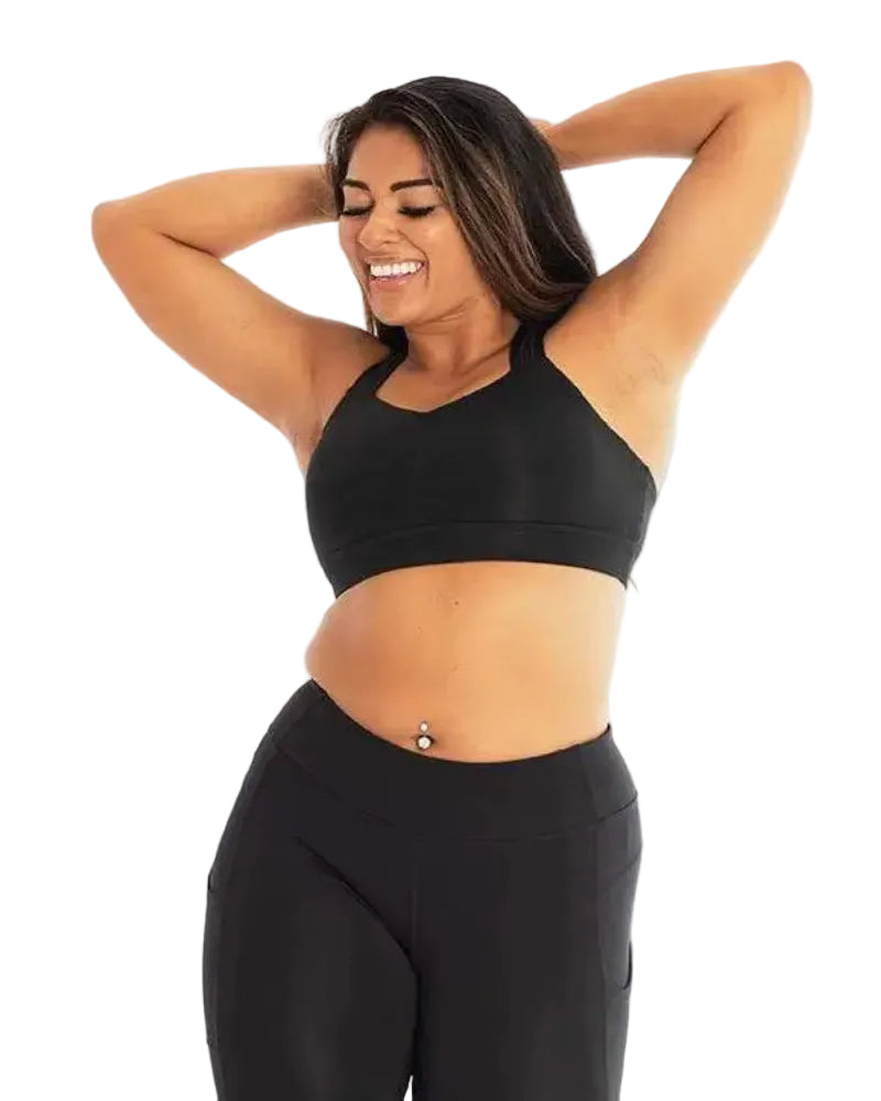 Woman wearing a black sports bra and leggings on a white background
