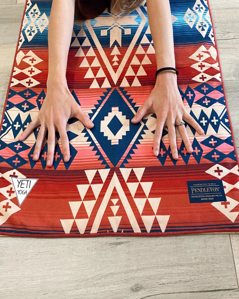 Person lying on a colorful Pendleton rug with YETI logo