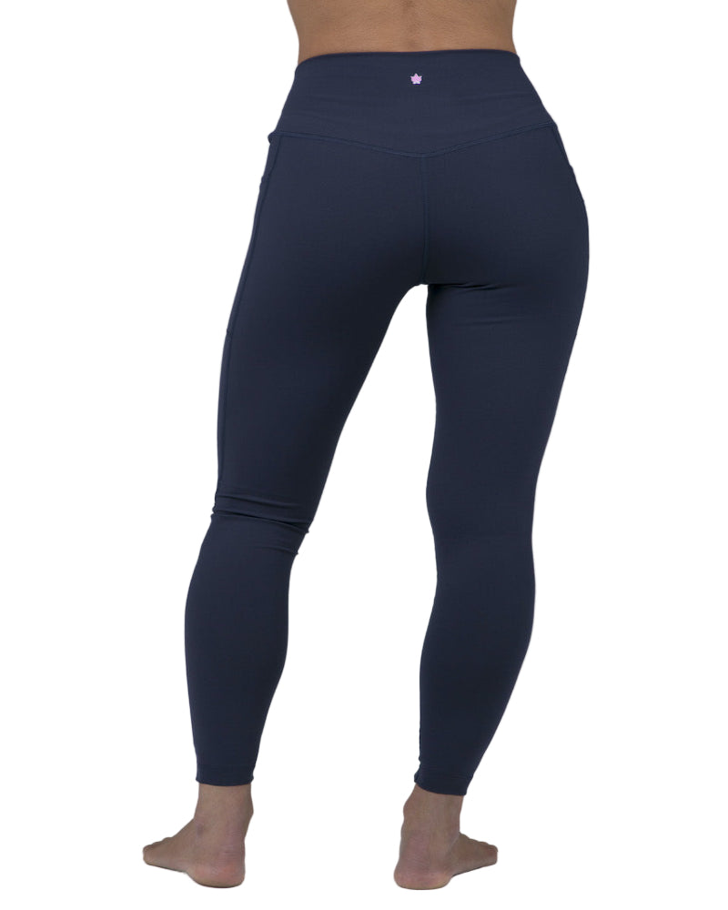 Navy blue leggings worn by a person on a gray background