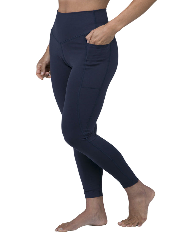 Navy leggings worn by a person on a gray background