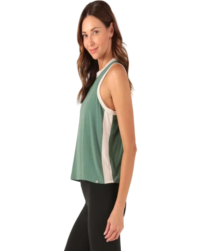 Woman wearing a green and white sleeveless top on a white background