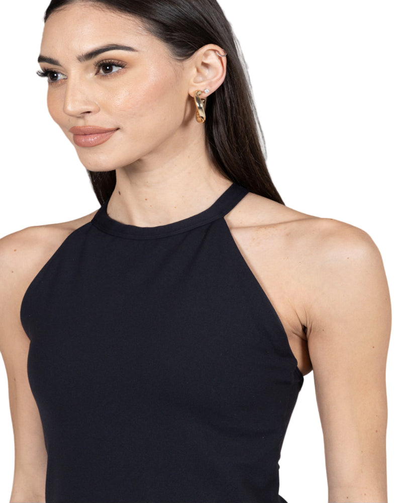 Woman wearing a black tank top against a gray background
