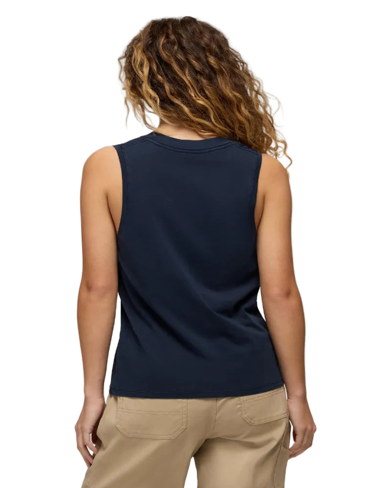 Person wearing a navy sleeveless top and beige pants on a white background