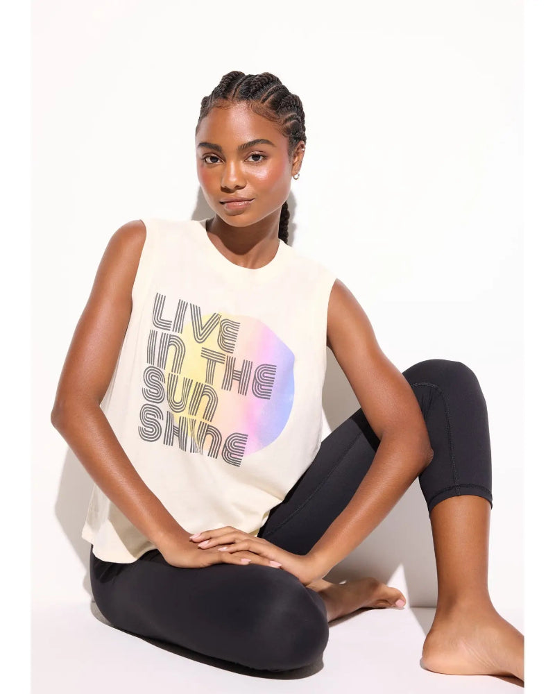 Woman wearing a sleeveless shirt with 'Live in the Sunshine' text on a white background