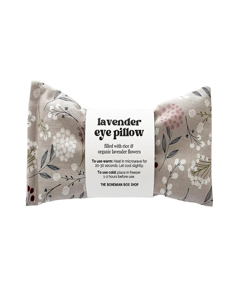 Lavender eye pillow with floral pattern and label on a white background