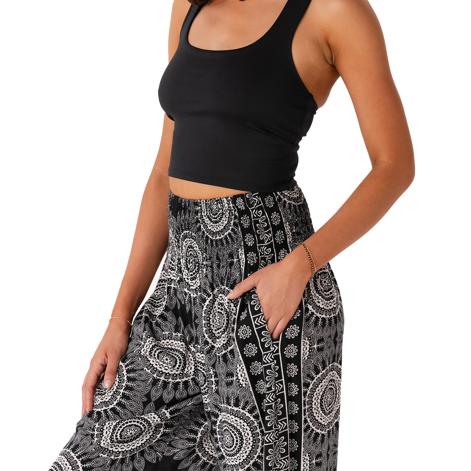 Person wearing a black crop top and patterned black and white pants on a white background