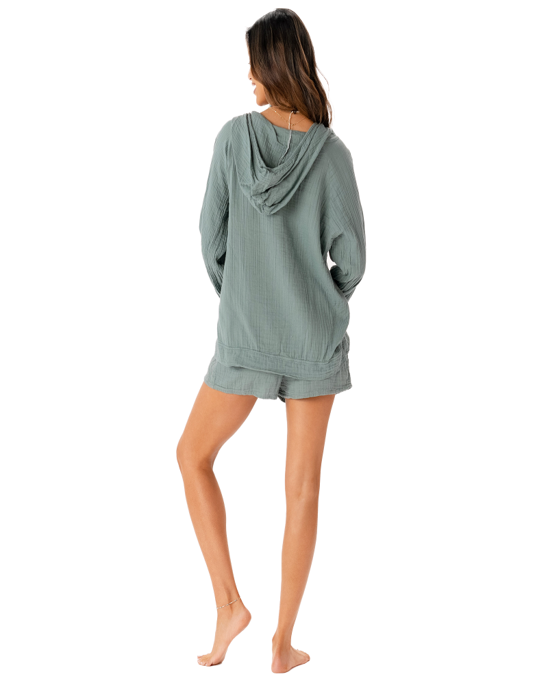 Woman wearing a green hoodie and shorts set on a white background