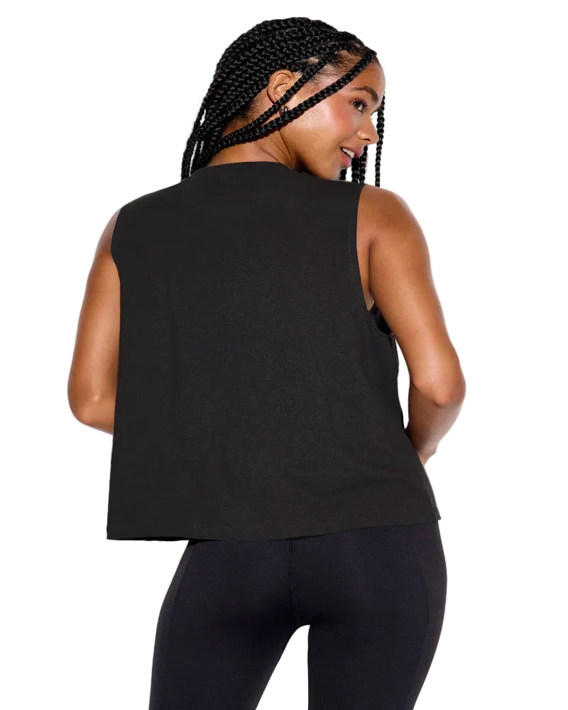 Woman wearing a black sleeveless top and leggings on a white background