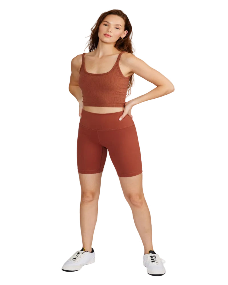 Woman wearing a brown athletic outfit on a white background