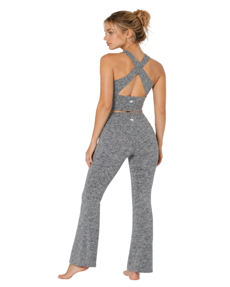 Woman wearing a gray jumpsuit with cut-out back design on a white background