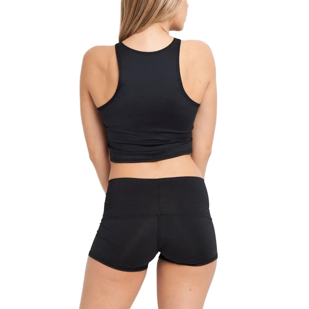 Person wearing a black sports bra and shorts on a light gray background