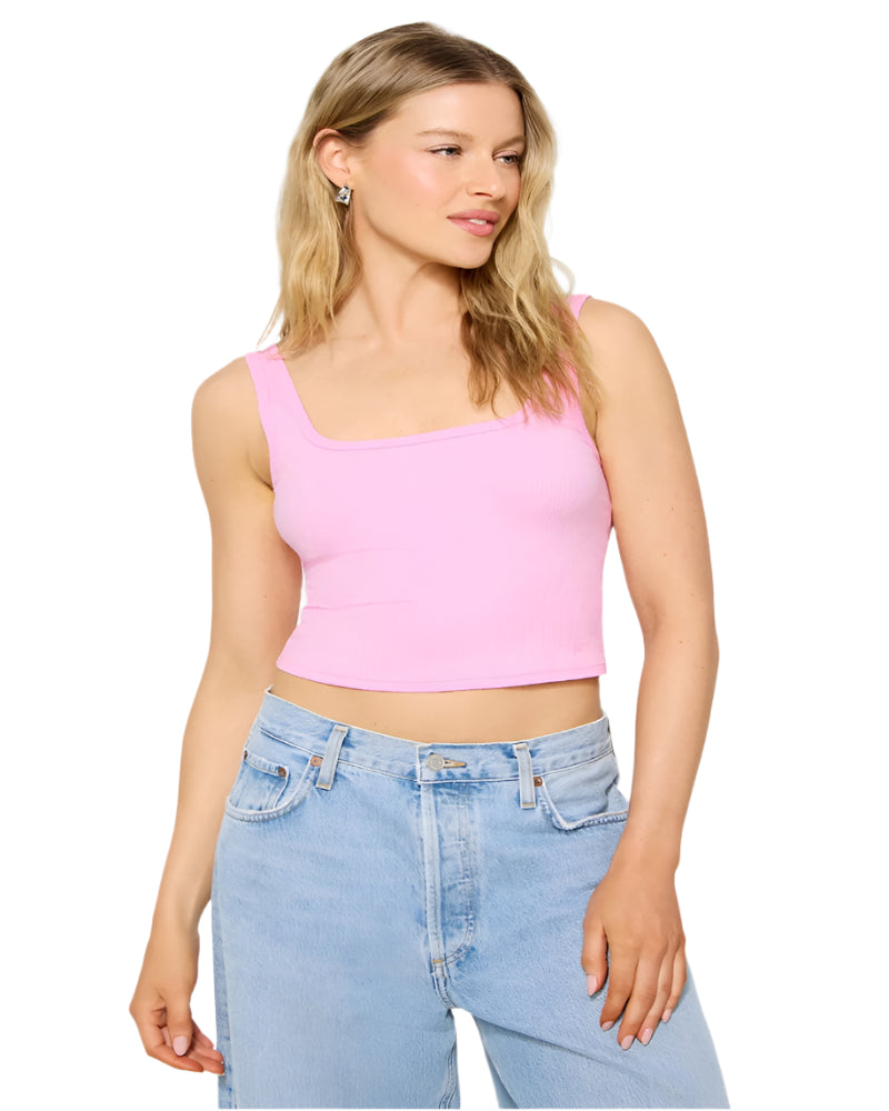 Woman wearing a pink crop top and blue jeans on a white background