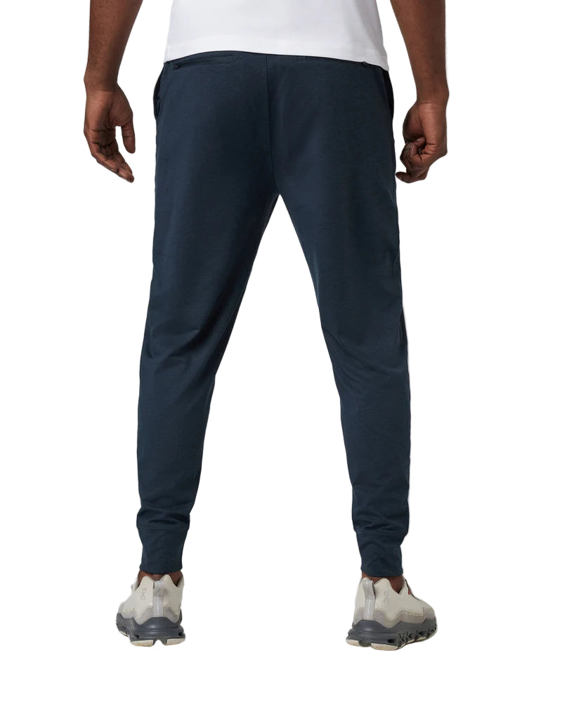 Person wearing navy jogger pants on a white background