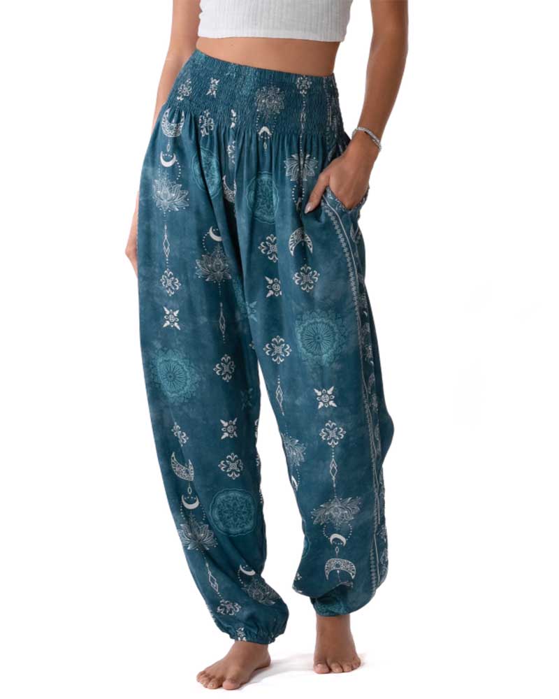 Teal patterned pants worn by a person on a white background