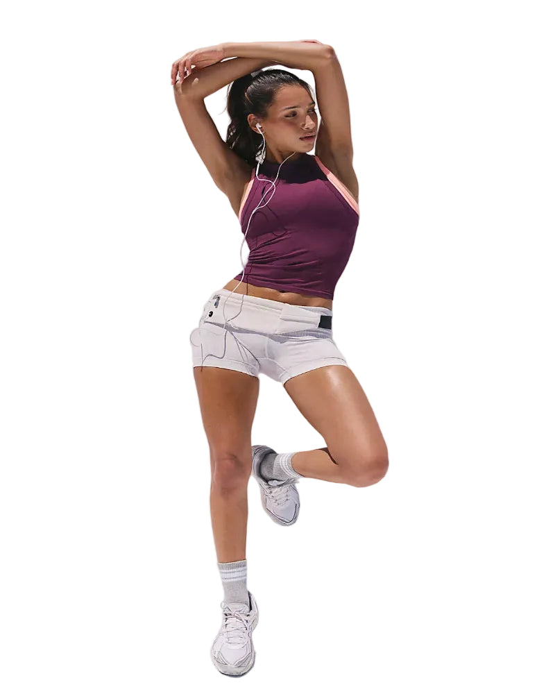 Woman in athletic wear posing against a white background