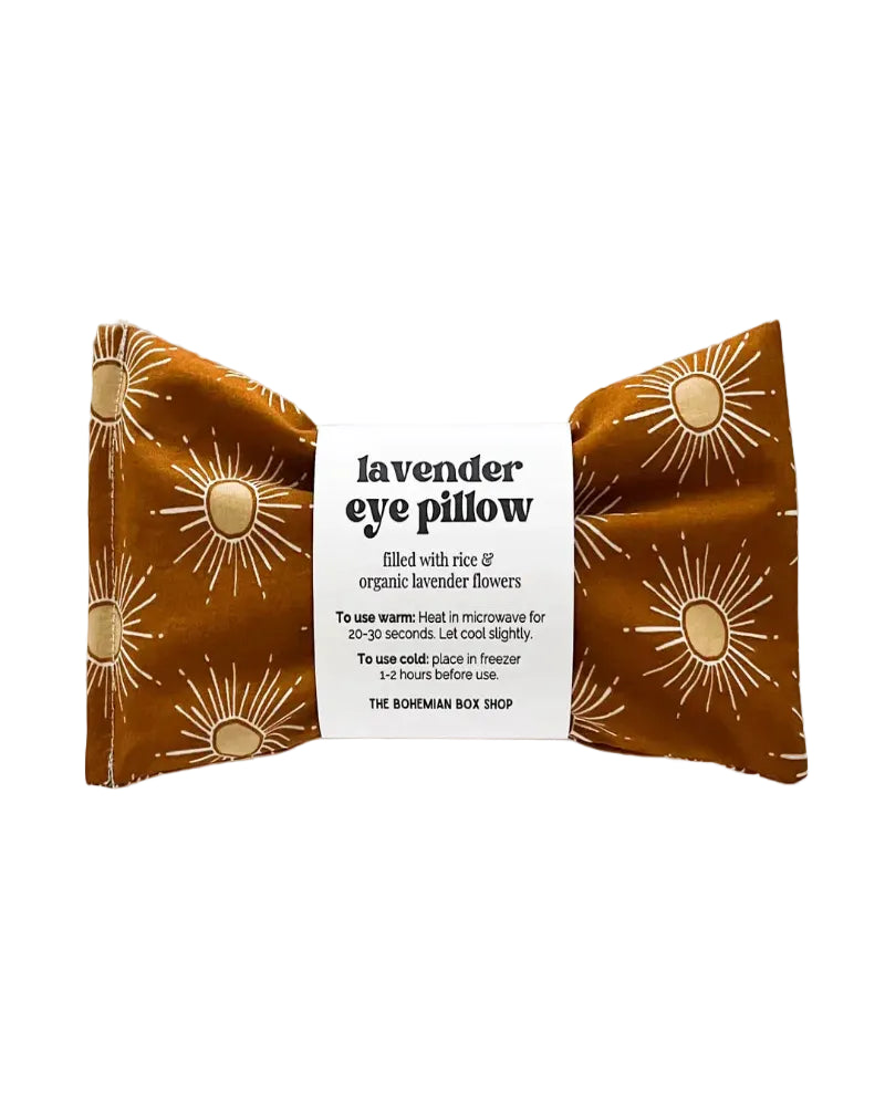 Lavender eye pillow with floral pattern and label on a white background