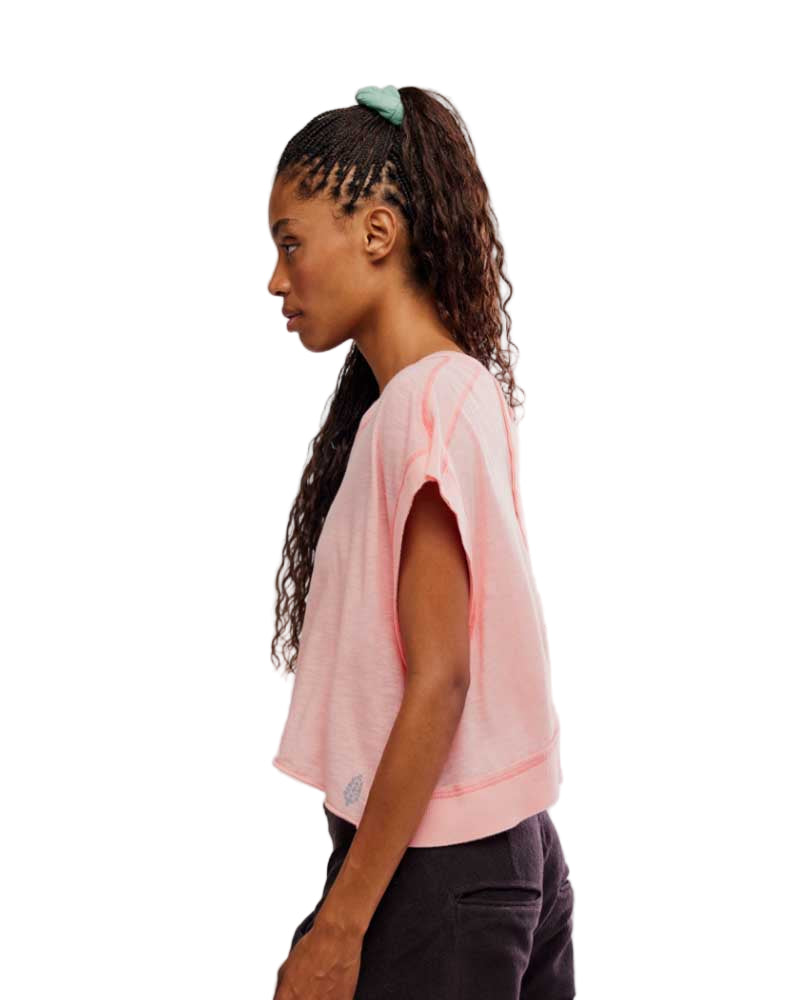Woman wearing a light pink t-shirt against a white background