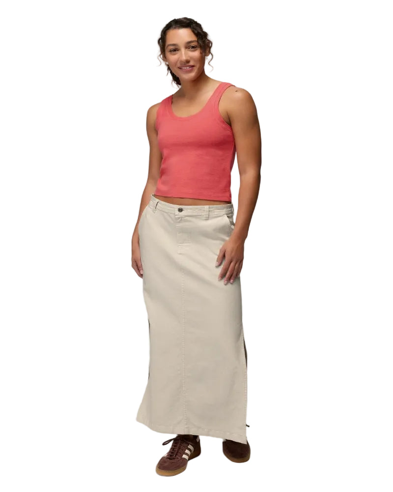 Woman wearing a coral tank top and beige skirt on a white background