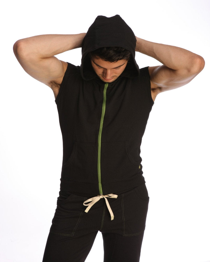 Person wearing a black sleeveless hoodie with a green zipper on a white background