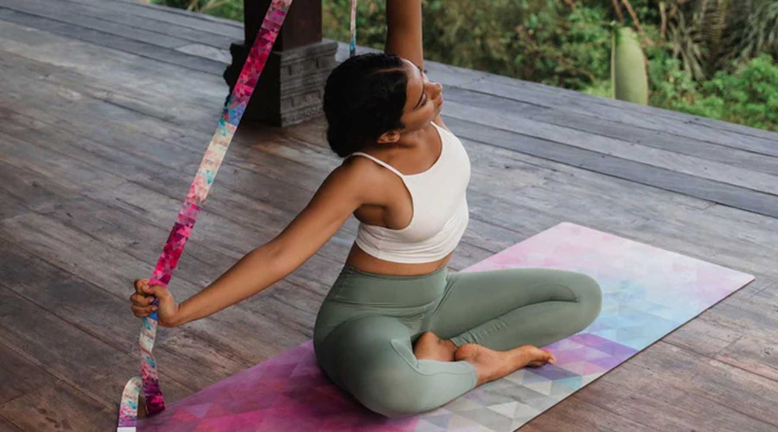 Person practicing yoga on a colorful mat with a hula hoop nearby