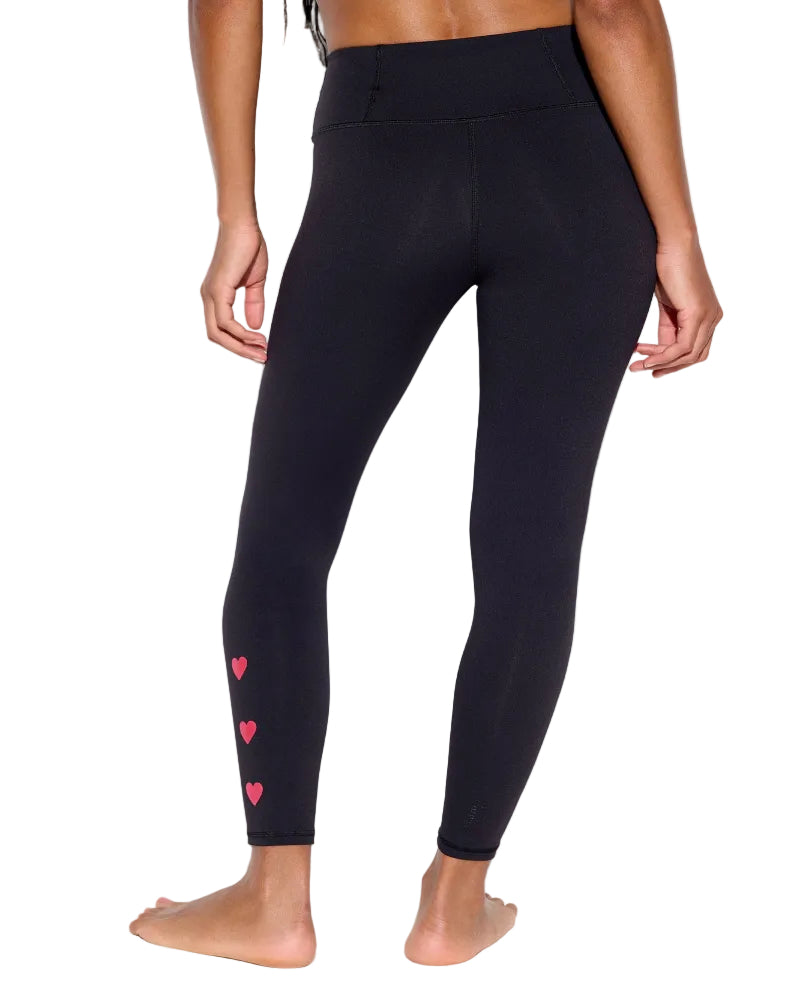 Black leggings with pink heart designs on a white background