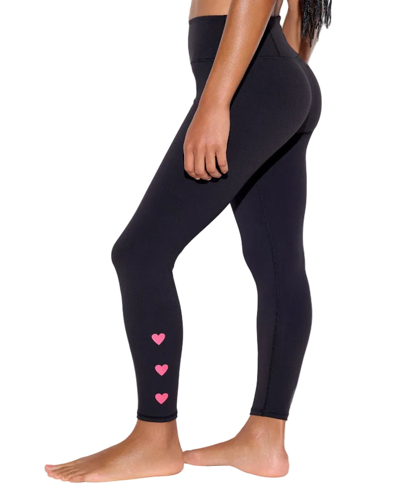 Black leggings with pink heart designs on a white background